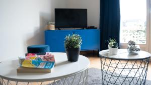 sala de estar con 2 mesas y TV en HAPPY MAMA COLMAR with PARKING en Colmar