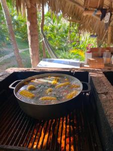 Eine Pfanne mit Essen kocht auf einem Grill in der Unterkunft Tropical Cottage En Eco Casa Algana in El Limón