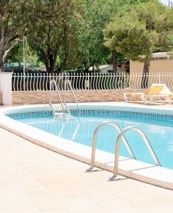 uma piscina com duas cadeiras e uma piscina em KT-0094 Magnífica Tienda Tipi - Camping Miramar Playa em Torredembarra