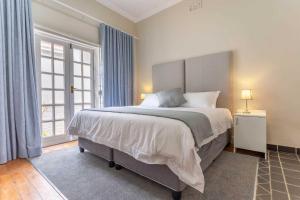 ein Schlafzimmer mit einem großen Bett und einem großen Fenster in der Unterkunft Middelberg Manor in Pretoria
