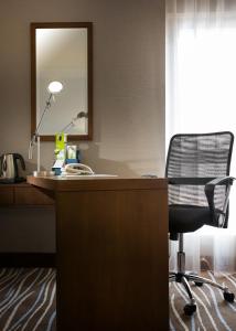 a desk with a chair and a mirror at Copthorne Downtown by Millennium in Abu Dhabi