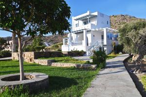 a white house with a tree in front of it at Galini Studios in Mikri Vigla