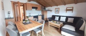 salon z kanapą i stołem z krzesłami w obiekcie Appartement Thunhart Manfred & Doris w mieście Altenmarkt im Pongau