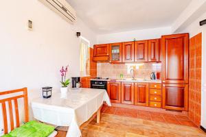 a kitchen with wooden cabinets and a table at Apartments Siri, 1 min walk to the beach in Korčula +46 photos