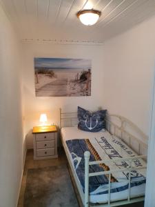 a small bedroom with a bed and a night stand at Lindi in Ostseebad Koserow