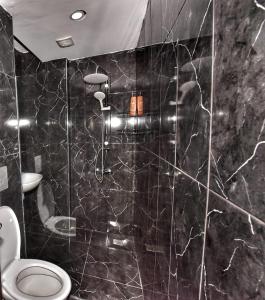 a bathroom with a toilet and a black marble wall at LORDS HOSTEL & PUB in Antalya