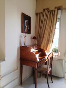escritorio de madera en una habitación con ventana en Πολυτελής κατοικία με θέα τον Θερμαϊκό, en Tesalónica
