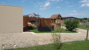 un patio trasero con una valla de madera y una casa en Soirée romantique avec Bain Nordique sur Domaine Equestre, Studio Tout Confort 
