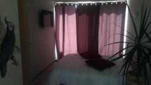 Schlafzimmer mit einem Bett und einem Fenster mit rosa Vorhängen in der Unterkunft Soirée romantique avec Bain Nordique sur Domaine Equestre, Studio Tout Confort 