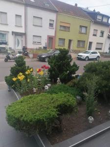 a garden with flowers and trees in a parking lot at Ferienwohnung Gabry in Saarlouis