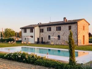 una casa con piscina frente a ella en Borgo Degli Angeli Resort e Spa, en San Vitale