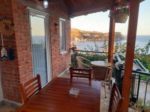 a patio with a table and chairs on a balcony at Stefanel View-Frederika in Himare