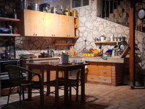 a kitchen with a wooden table and chairs and a table and a counter at Stefanel View-Frederika in Himare