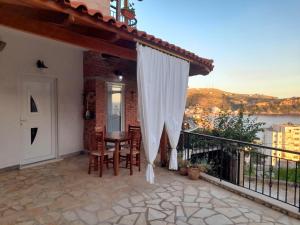 a patio with a table and chairs on a balcony at Stefanel View-Frederika in Himare
