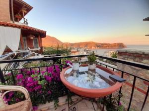 a balcony with a table and flowers at Stefanel View-Frederika in Himare