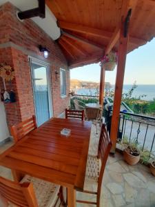 a wooden table on a balcony with a view of the ocean at Stefanel View-Frederika in Himare