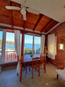 a dining room with a table and some windows at Stefanel View-Frederika in Himare