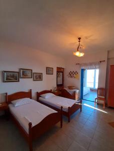 a bedroom with two beds and a living room at Stefanel View-Frederika in Himare
