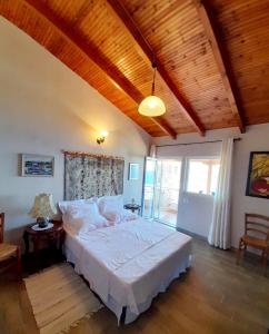a bedroom with a large bed with a wooden ceiling at Stefanel View-Frederika in Himare