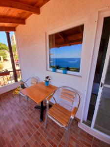 a table and chairs on a porch with a view of the ocean at Stefanel View-Frederika in Himare