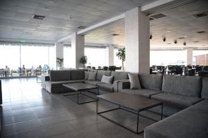 a lobby with couches and tables in a building at Royal Bay Suites in Kefalos