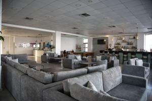 a large room with couches and tables and a bar at Royal Bay Suites in Kefalos