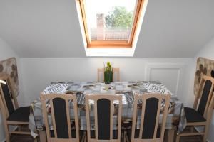 mesa de comedor con sillas y ventana en Lencsi ház, en Abádszalók