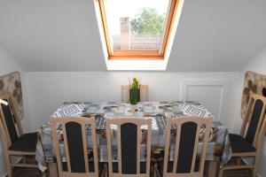 une table à manger avec des chaises et une fenêtre dans l'établissement Lencsi ház, à Abádszalók