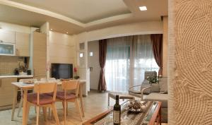 アテネにあるA7 Beauty Vouliagmeni Apt in a unique Spotのテーブルと椅子のあるキッチンとリビングルーム