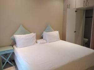 a large white bed with two pillows on it at Posh 2 in Durban