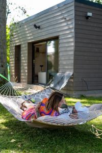 een vrouw in een hangmat in een tuin bij Capsule Nature & Photos - Jacuzzi - Netflix & Home cinéma - PS5 & jeu in Thun-Saint-Martin