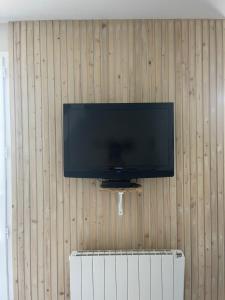 a flat screen tv hanging on a wooden wall at Maison 6pers à 800m de la mer SAINTE-CÉCILE PLAGE in Camiers +13 photos