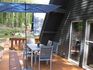 a table with chairs and an umbrella on a deck at Ferienhaus Twistesee 93 in Wetterburg