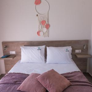 elenamou seaview rooms في أمولياني: غرفة نوم مع سرير مع وسادتين