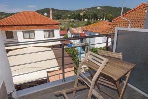 a wooden chair sitting on a balcony with a view at elenamou rooms in Ammouliani