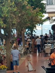 un grupo de personas caminando por una acera cerca del océano en Beach Apartments Old Town, en Estepona