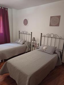- une chambre avec 2 lits et une fenêtre dans l'établissement Estrella Mudejar, à Teruel