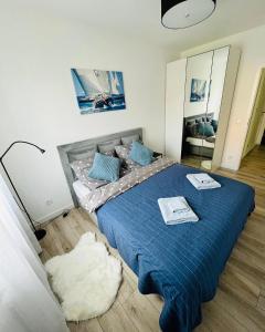 een slaapkamer met een blauw bed met 2 handdoeken erop bij Apartament Przy Plaży Rewal in Rewal