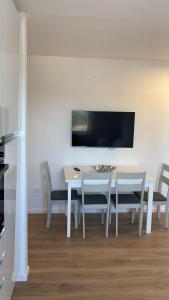 une salle à manger avec une table et des chaises blanches dans l'établissement APP Robi, à Novigrad