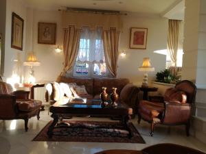 uma sala de estar com um sofá, cadeiras e uma mesa em Πολυτελής κατοικία με θέα τον Θερμαϊκό em Tessalônica