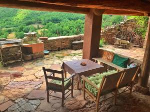 patio con mesa, sillas y fogones en Casa Manel - Loft rústico con encanto, en Montcortès