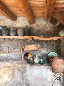 un estante con varios jarrones y jarrones. en Casa Manel - Loft rústico con encanto, en Montcortès
