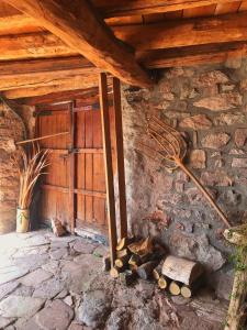 un edificio con una puerta y un montón de madera en Casa Manel - Loft rústico con encanto, en Montcortès