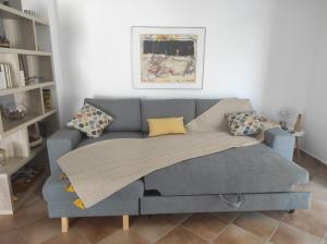 a couch with a blanket on it in a living room at AZALEA - Modern studio with sea view in Galatas