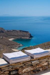 a group of mattresses sitting on top of a hill next to the ocean at Kea Ciel Villa in Ioulis