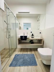 een badkamer met een wastafel, een toilet en een douche bij Apartament Przy Plaży Rewal in Rewal