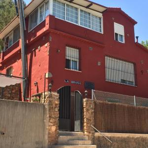 una casa roja con una puerta y una valla en La Buena Siesta, en Ruidera