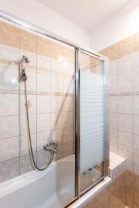 a shower with a glass door in a bathroom at EXELLENT GUEST VILLA PRESTIGE in Asprogerakata