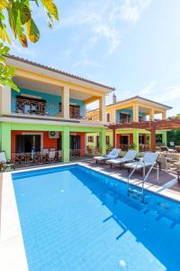 a villa with a swimming pool in front of a house at EXELLENT GUEST VILLA PRESTIGE in Asprogerakata