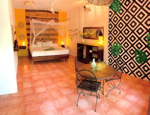 a room with a bed and a table and chairs at Hotel Casa Mixteca in Zipolite